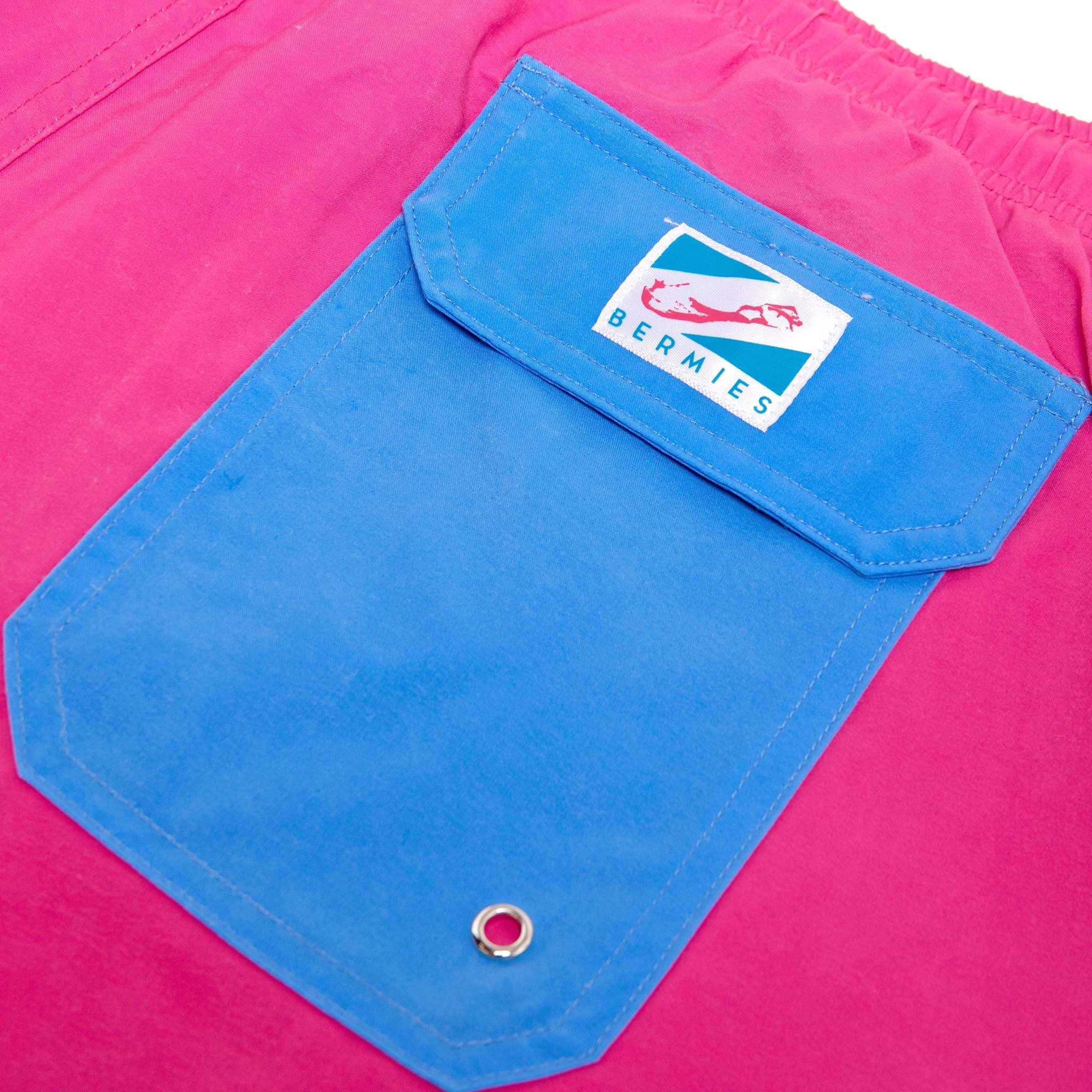 Magenta blue swim trunks with pockets and elastic key loop, designed for comfort and style.