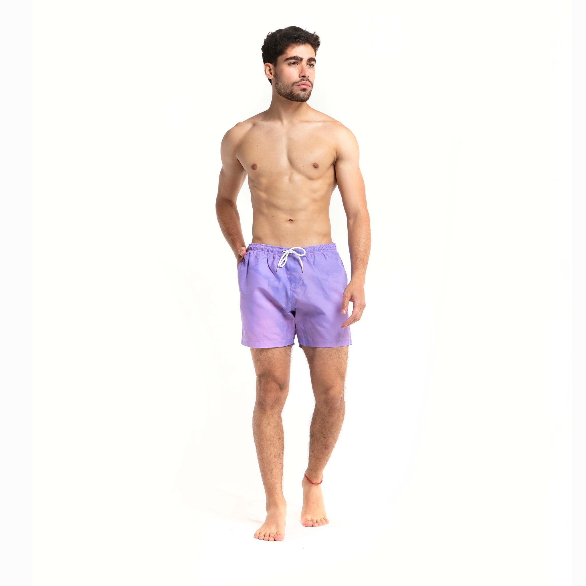 Color-changing Pink to Purple 5" Swim Trunks displayed on a beach setting, showcasing their vibrant colors and eco-friendly design.