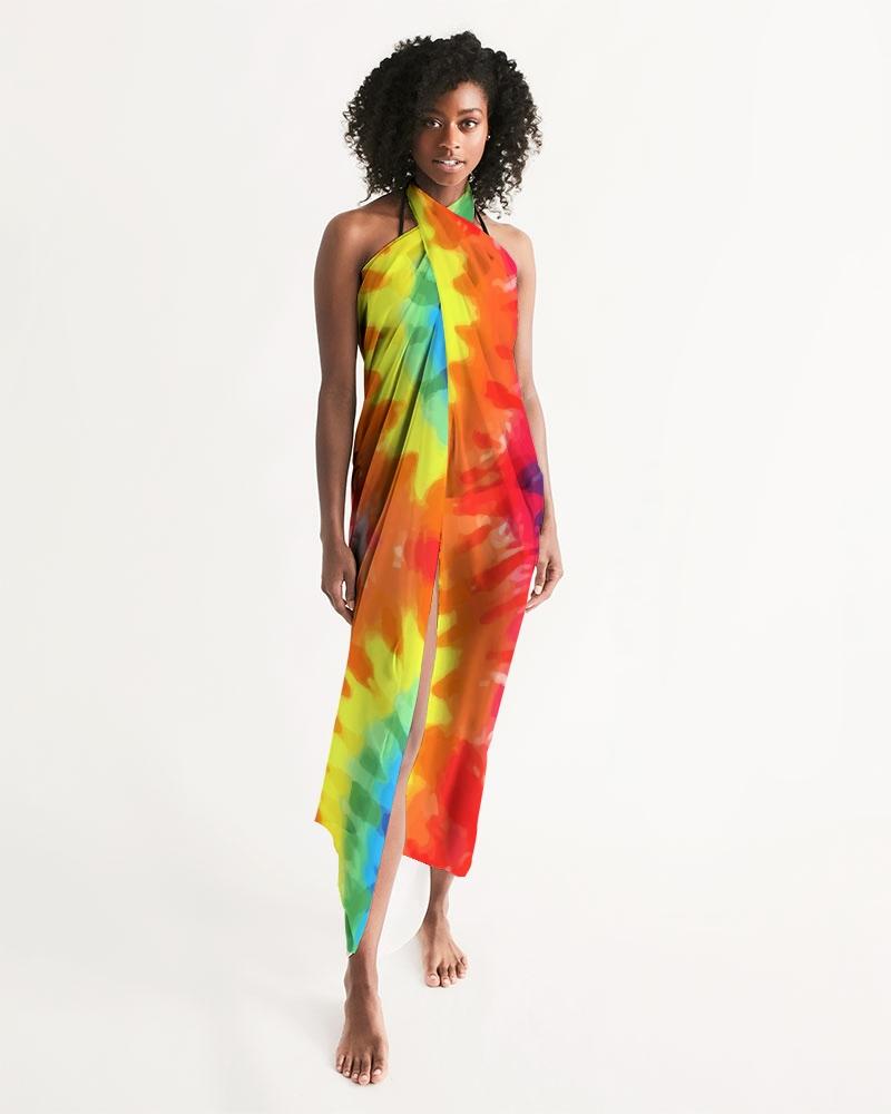 A vibrant sheer rainbow tie dye swimsuit cover up draped elegantly over a beach chair, showcasing its lightweight fabric and self-tie closure.