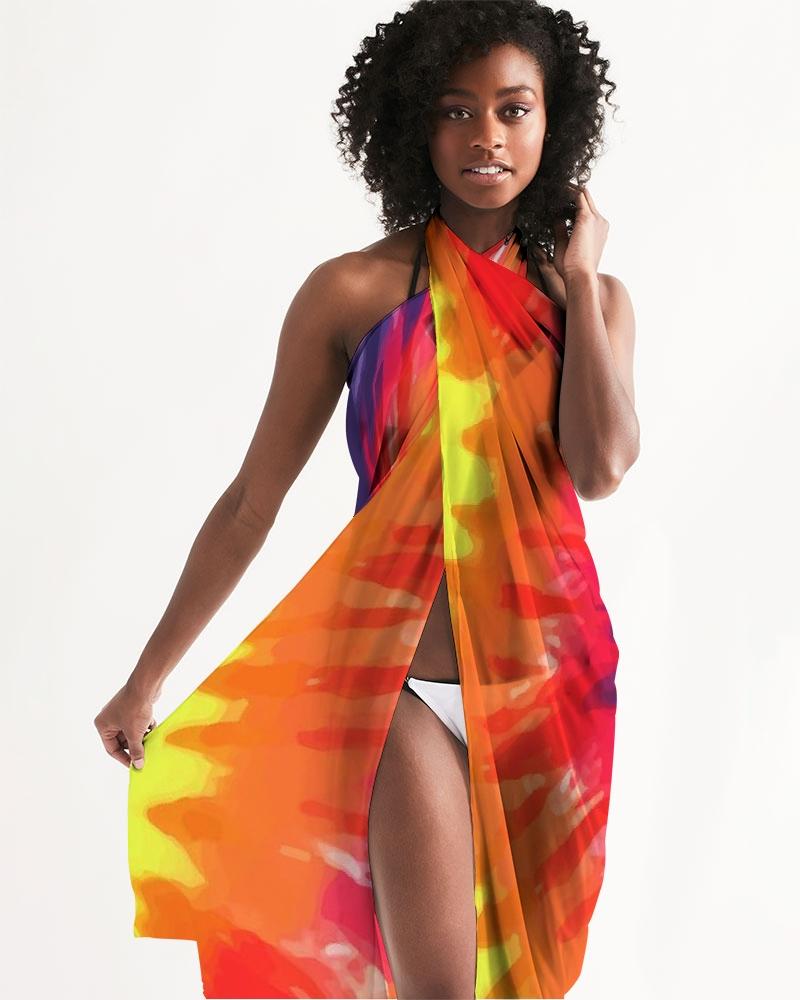 A vibrant sheer rainbow tie dye swimsuit cover up draped elegantly over a beach chair, showcasing its lightweight fabric and self-tie closure.