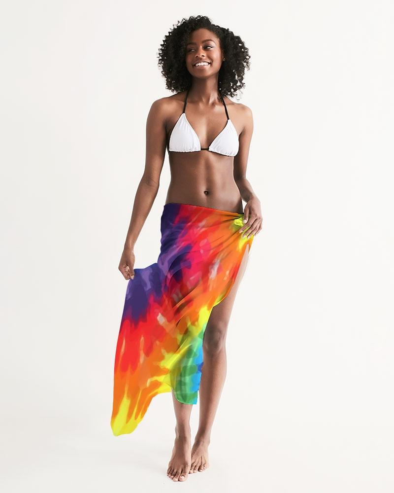 A vibrant sheer rainbow tie dye swimsuit cover up draped elegantly over a beach chair, showcasing its lightweight fabric and self-tie closure.