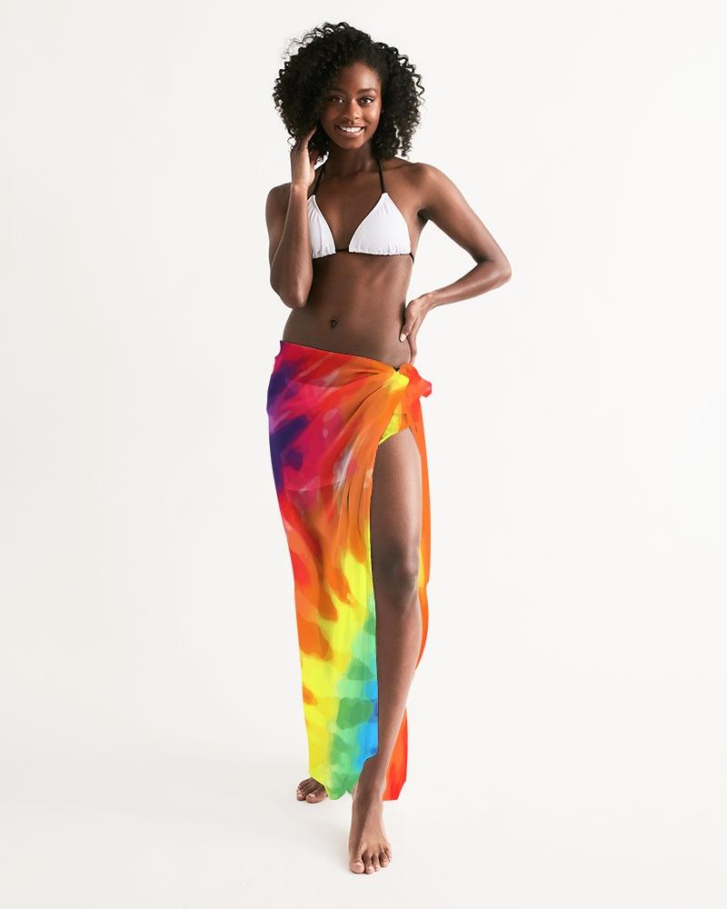 A vibrant sheer rainbow tie dye swimsuit cover up draped elegantly over a beach chair, showcasing its lightweight fabric and self-tie closure.