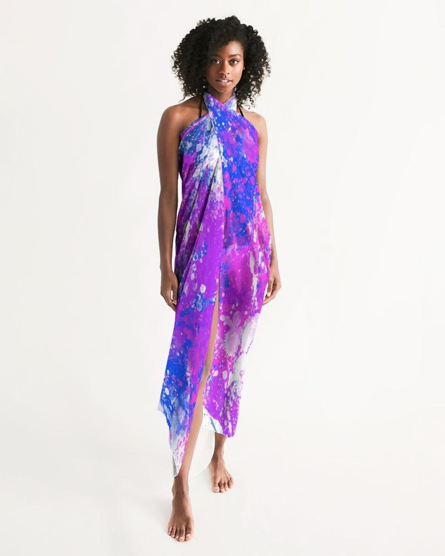 A lightweight sheer sarong swimsuit cover up wrap in purple tie dye, elegantly draped on a beach setting.