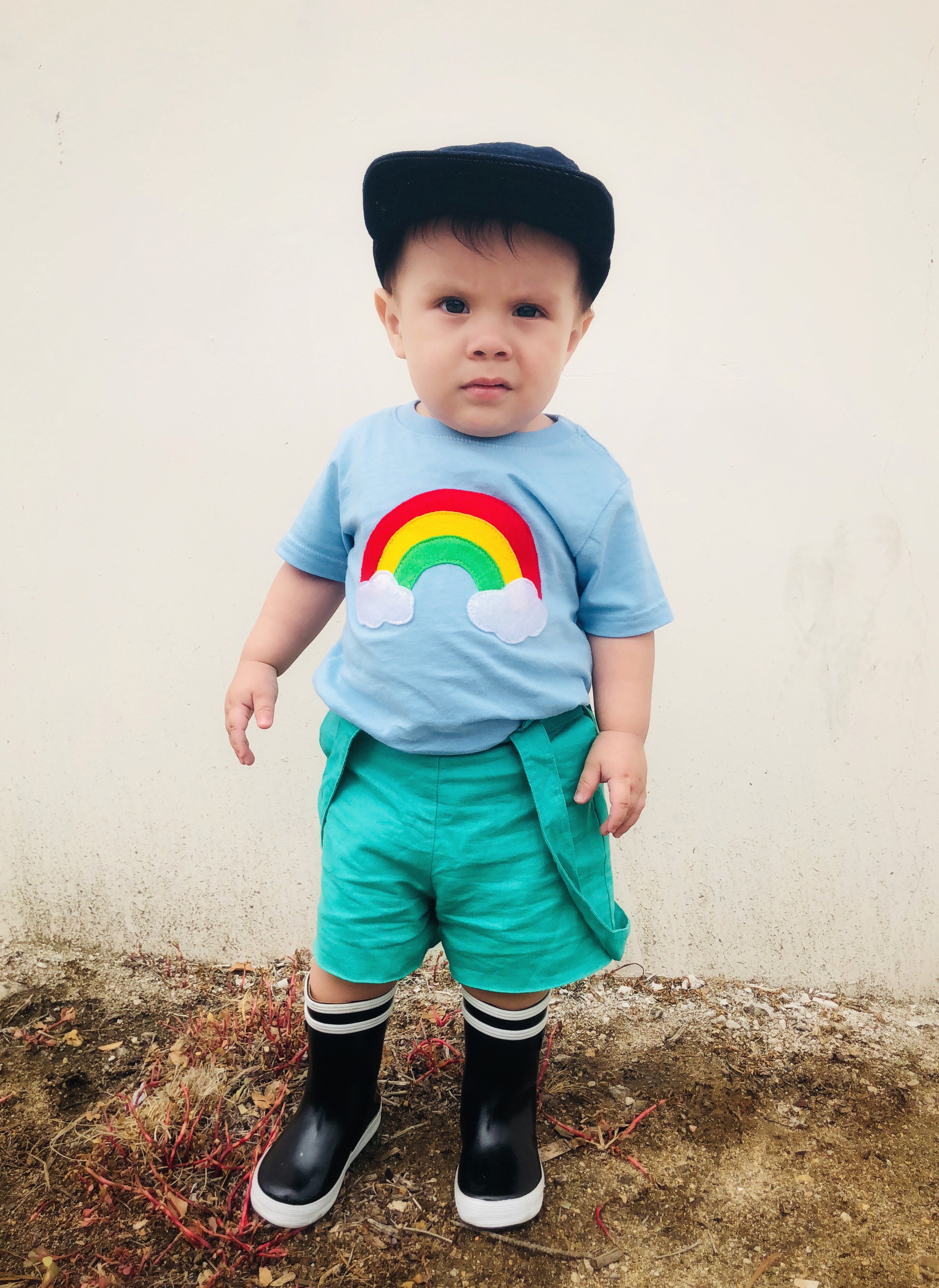 Aloha Rainbow Kids Baby Blue Shirt featuring a colorful rainbow design on a soft blue background, perfect for boys and girls.