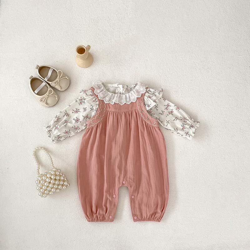 A baby girl wearing a floral print long sleeves top in pink, paired with a pink strap, showcasing a stylish autumn outfit.