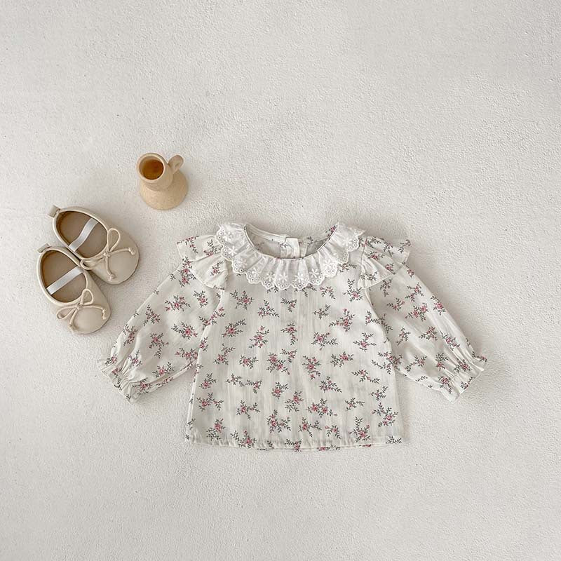 A baby girl wearing a floral print long sleeves top in pink, paired with a pink strap, showcasing a stylish autumn outfit.