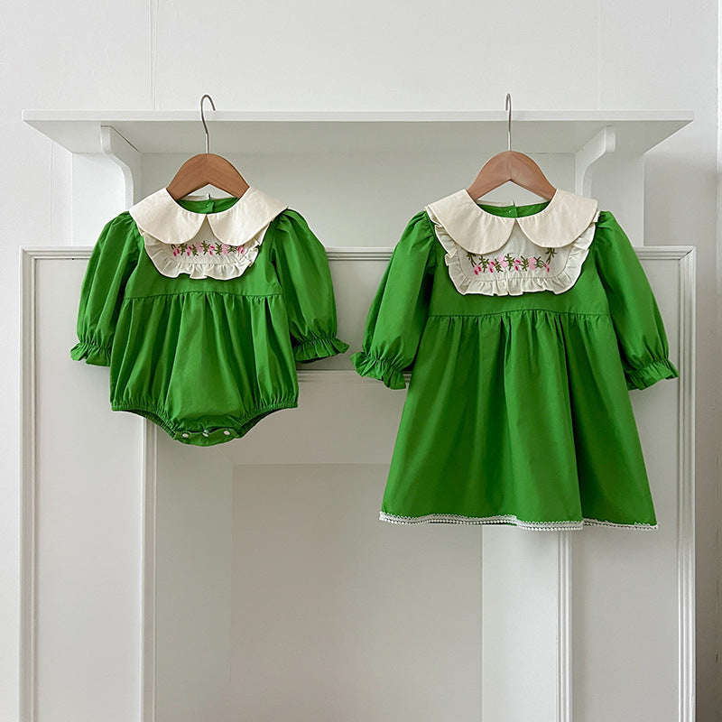 A stylish Arrival Autumn Baby Kids Girls dress featuring long sleeves and a Peter Pan collar in green and beige colors, adorned with an embroidered pattern.