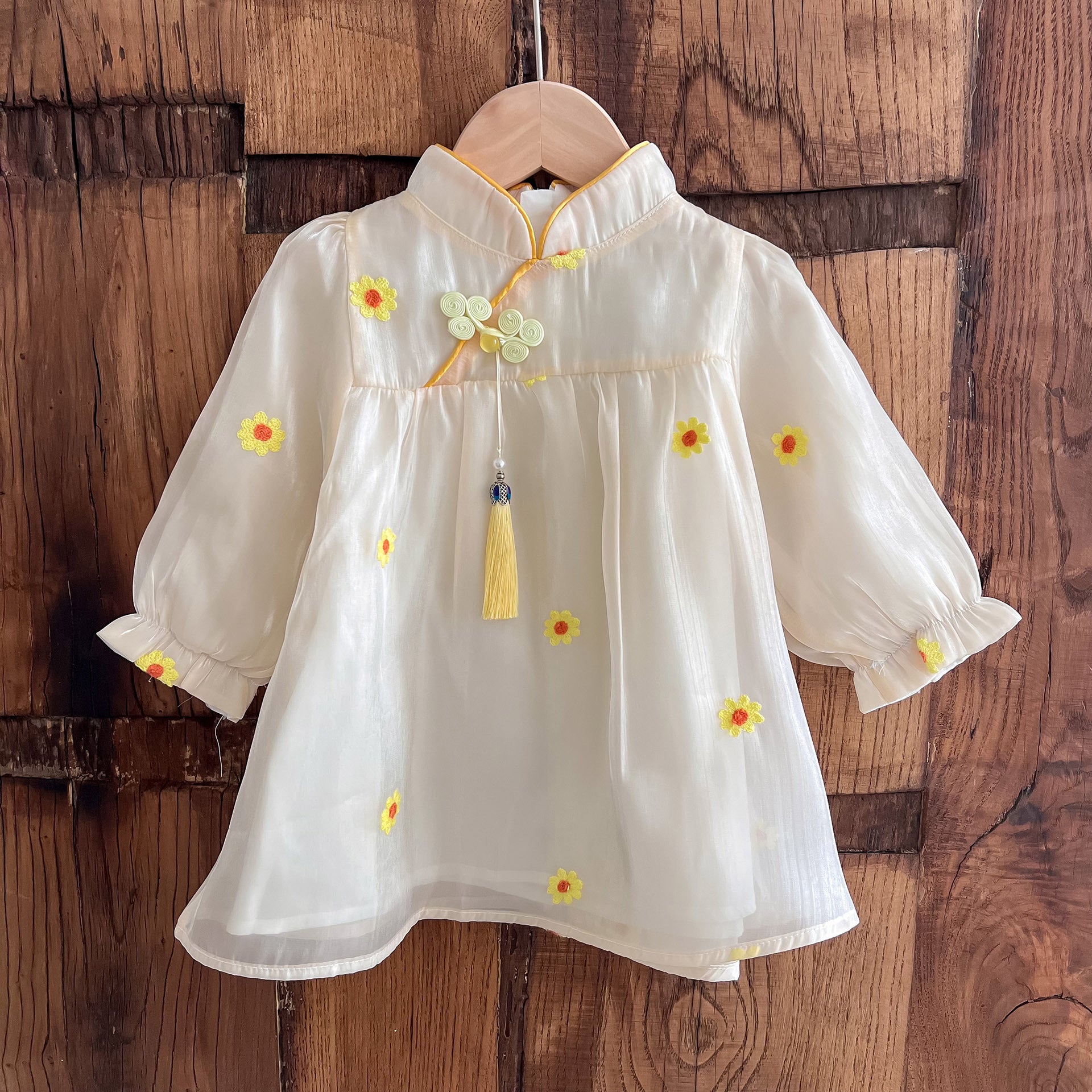 A stylish long-sleeve top for girls featuring a daisy flower pattern and stand collar, perfect for autumn and spring wear.