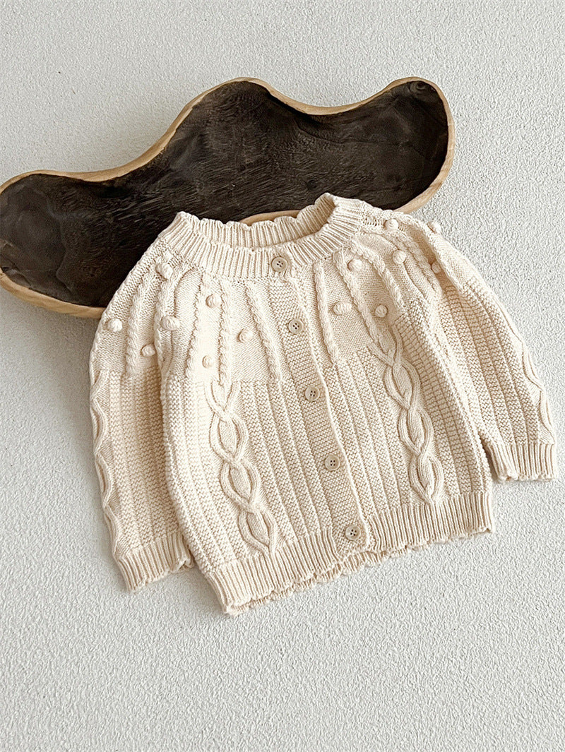 A beige and coffee long-sleeved cardigan for baby girls featuring a playful hairball design, made from soft cotton material.