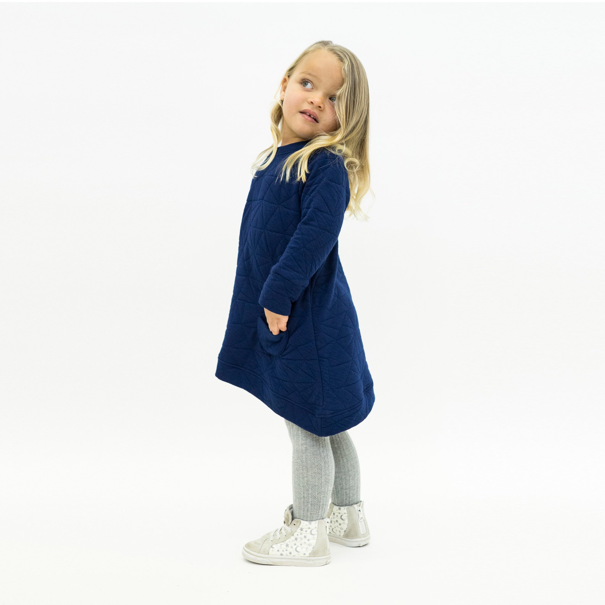 Asymmetric dress in quilted deep blue with a unique design, featuring a monster peek-a-boo pocket and thumbholes for toddlers.