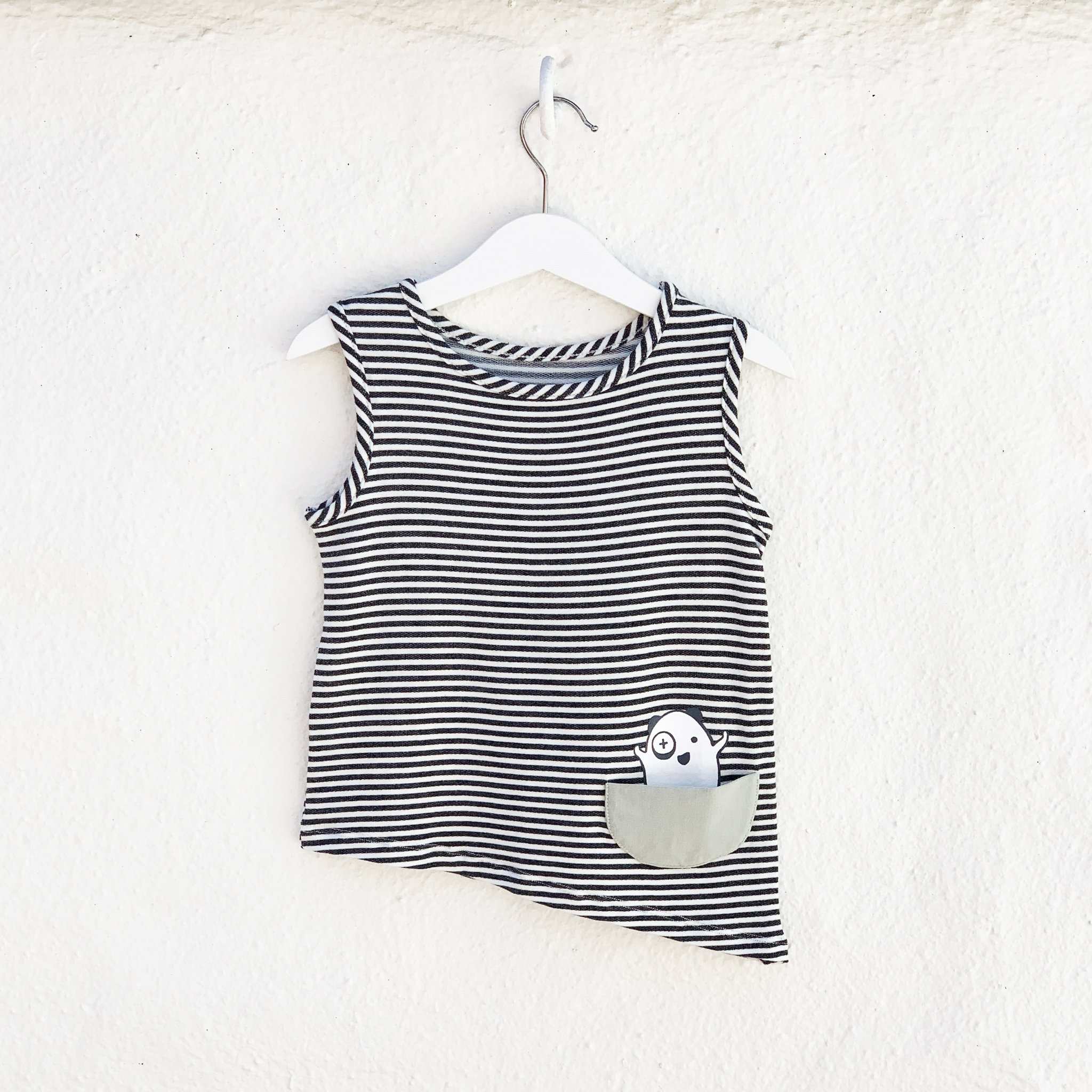 Asymmetric Tank in Black and White Stripes featuring a unique hem and monster pocket.