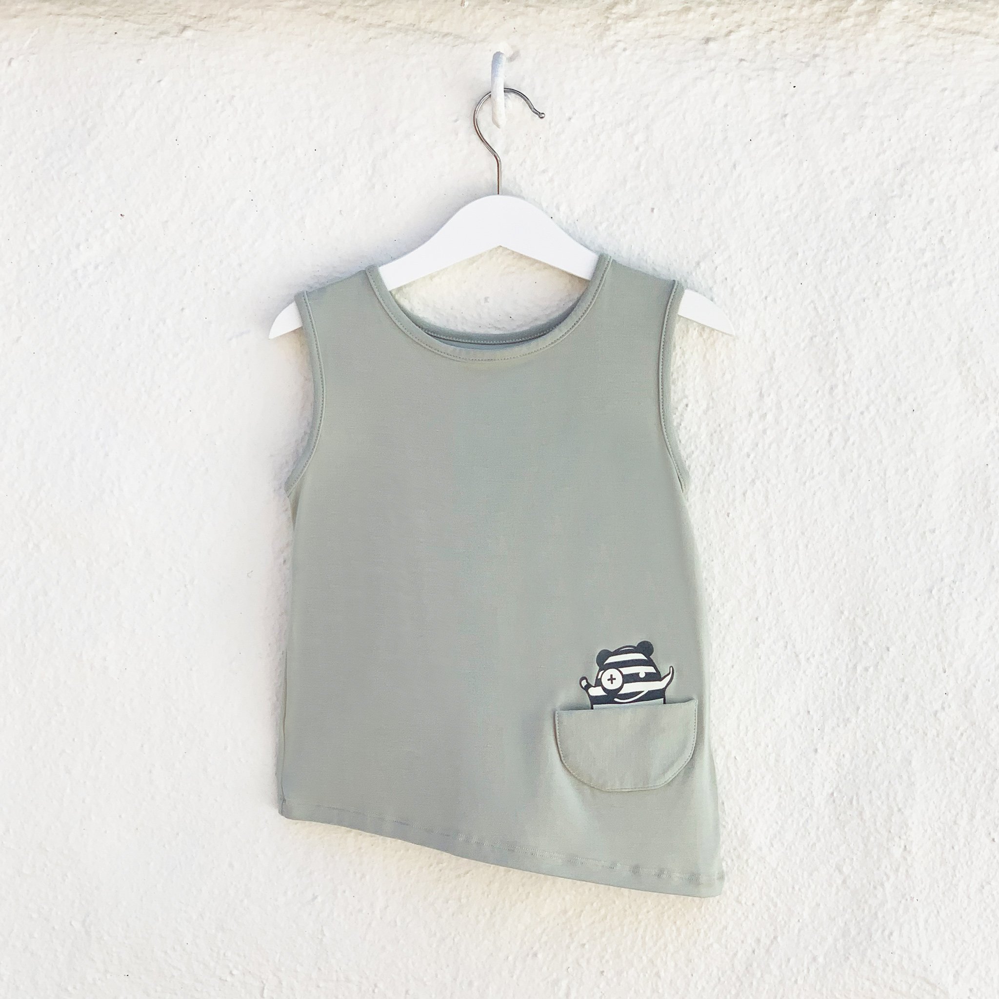 Asymmetric Tank in Desert Sage featuring a unique hem and monster pocket, made from soft rayon modal fabric.