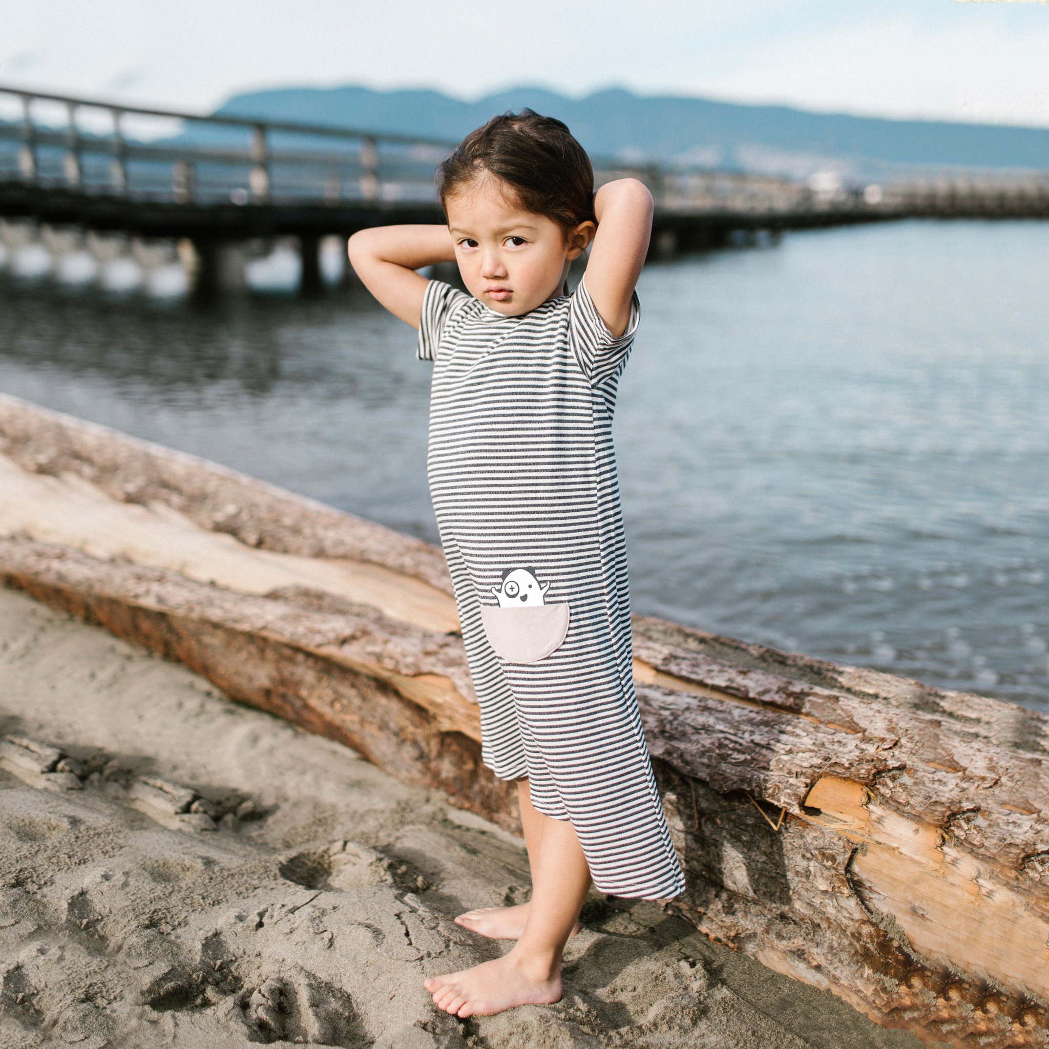 Asymmetric T-shirt Dress in black and white stripes with a monster peek-a-boo pocket, perfect for toddlers.