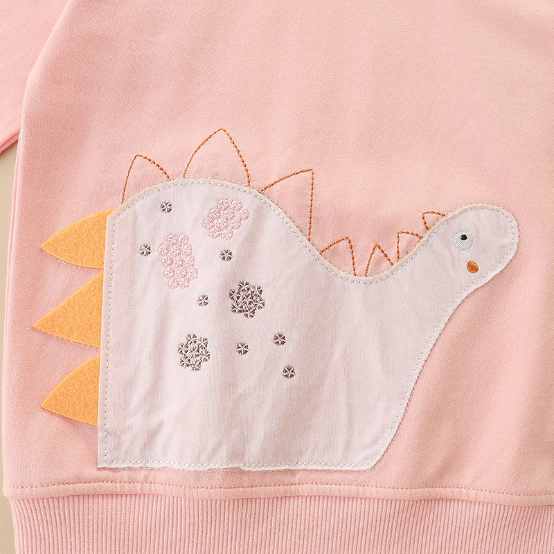 A pink soft cotton hoodie featuring an adorable dinosaur pattern, perfect for young girls.