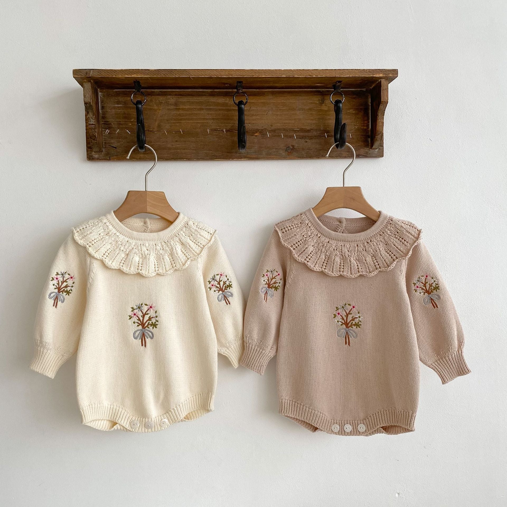 A cozy autumn knitted onesie for baby girls, featuring floral embroidery in beige and brown colors, perfect for the fall season.