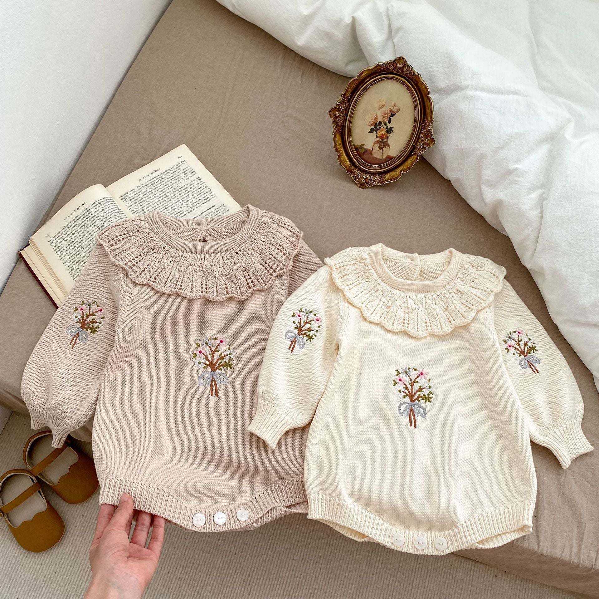 A cozy autumn knitted onesie for baby girls, featuring floral embroidery in beige and brown colors, perfect for the fall season.