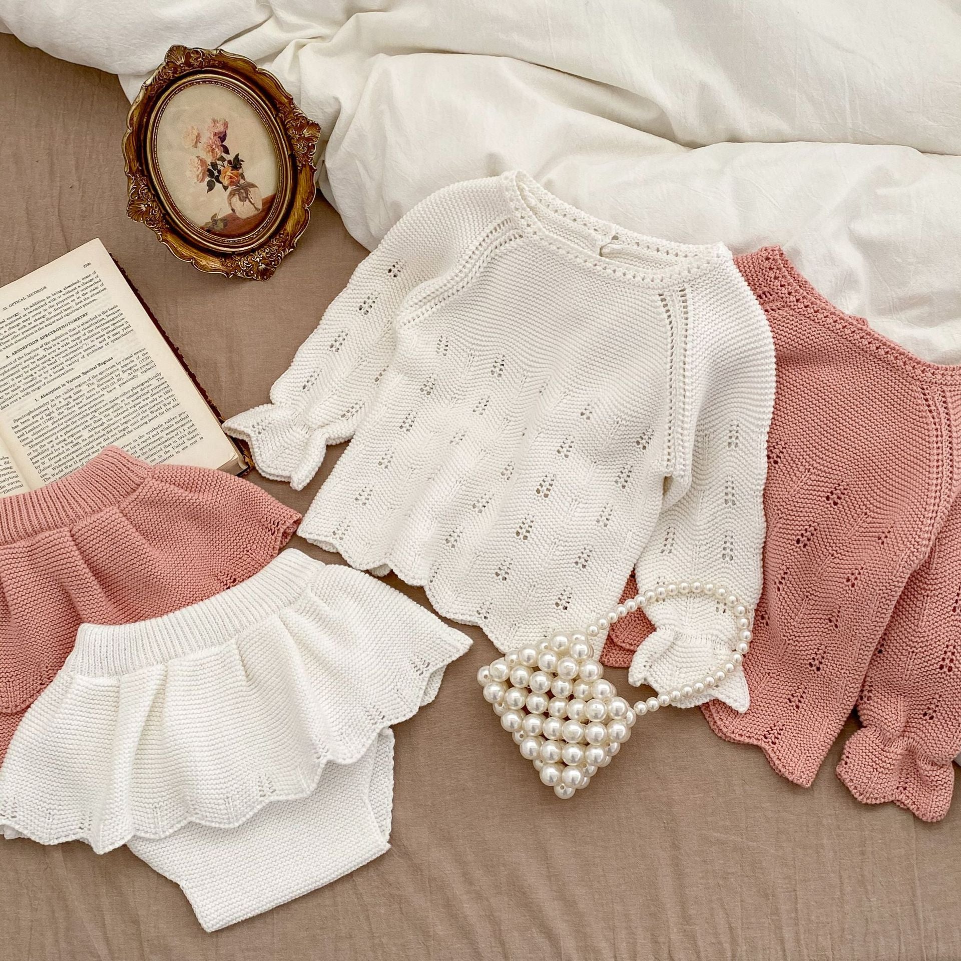 Autumn Hollow Carved Design Solid Color Knitted Sets in white and pink for baby girls, showcasing a cozy and stylish design.