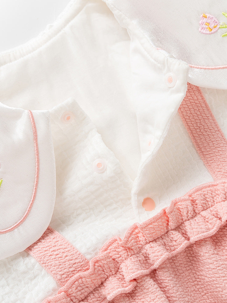 A pink baby girl's dress featuring floral embroidery on the collar and a patchwork pattern, perfect for autumn and spring wear.