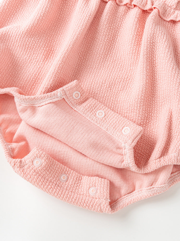 A pink baby girl's dress featuring floral embroidery on the collar and a patchwork pattern, perfect for autumn and spring wear.