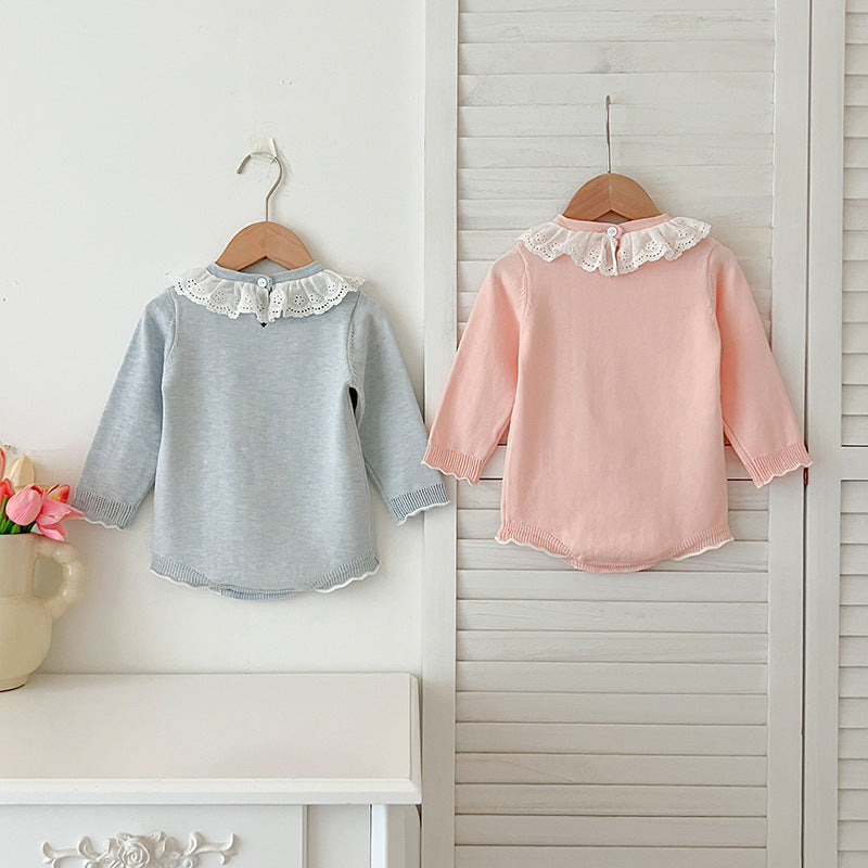 A baby girl wearing a long-sleeved hollow-out striped dress in pink and blue, showcasing a stylish autumn design.