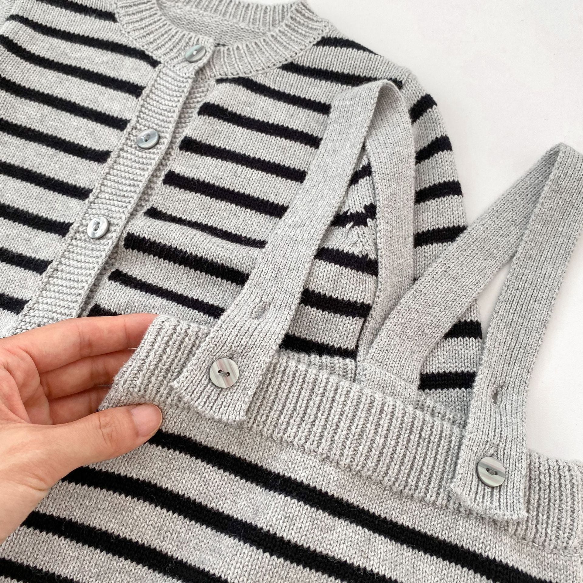 A stylish grey knitted overall set with striped pattern, perfect for autumn wear for babies.