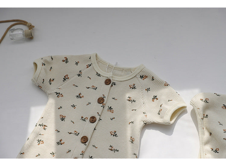 Baby jumpsuit featuring an allover floral graphic pattern and solid bodice, designed for comfort and style.