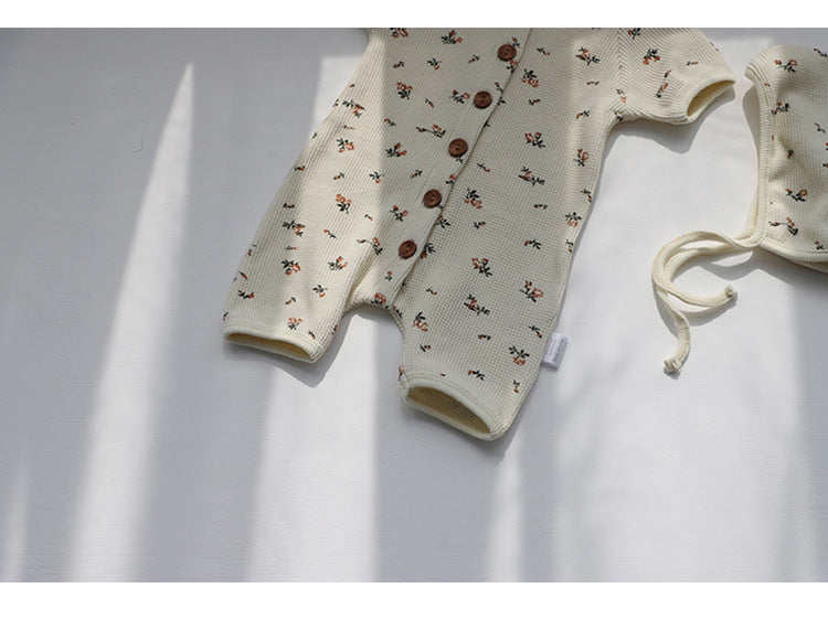 Baby jumpsuit featuring an allover floral graphic pattern and solid bodice, designed for comfort and style.