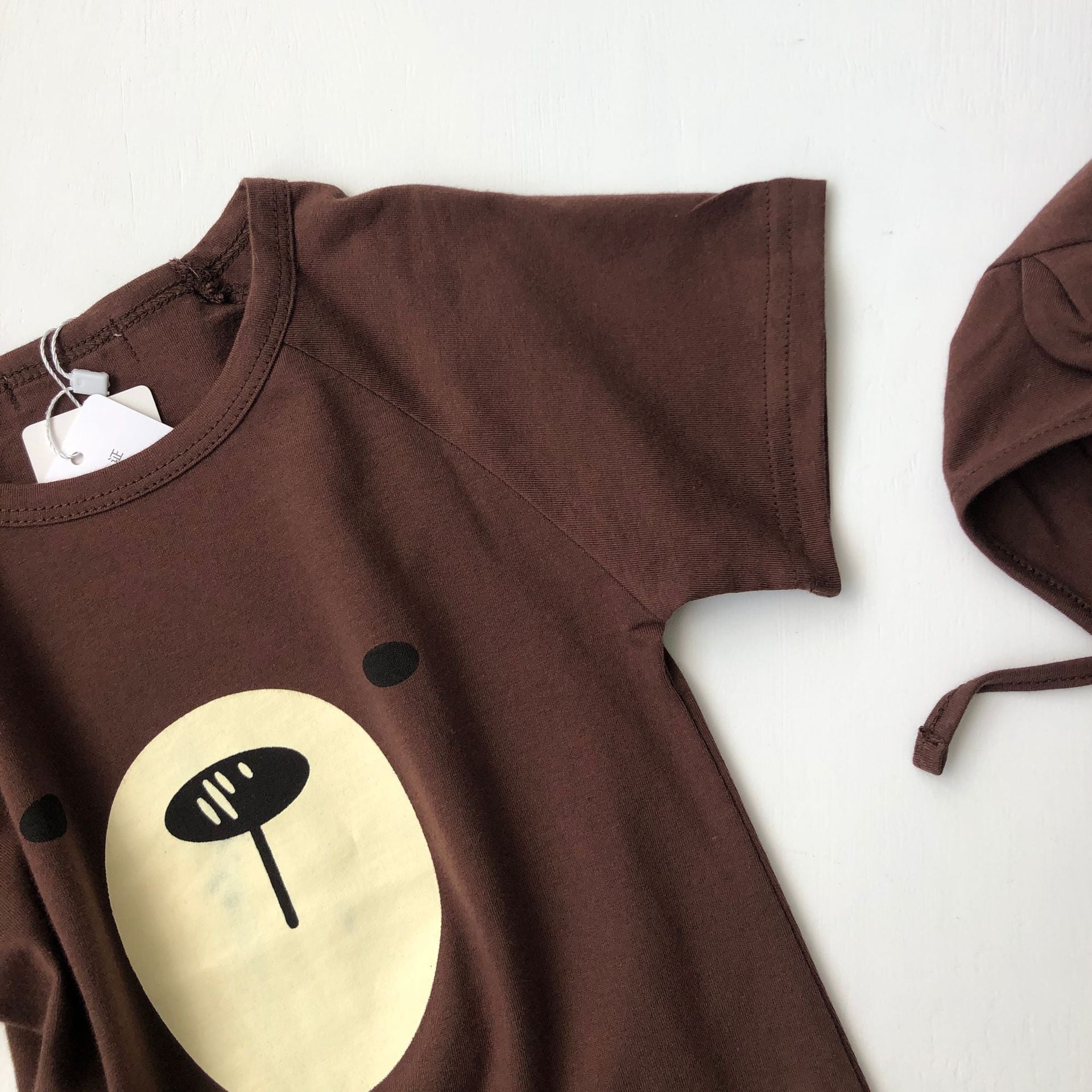 A cute baby wearing a Cartoon Bear Graphic Crotchet Jumpsuit in soft cotton, showcasing the adorable bear design.