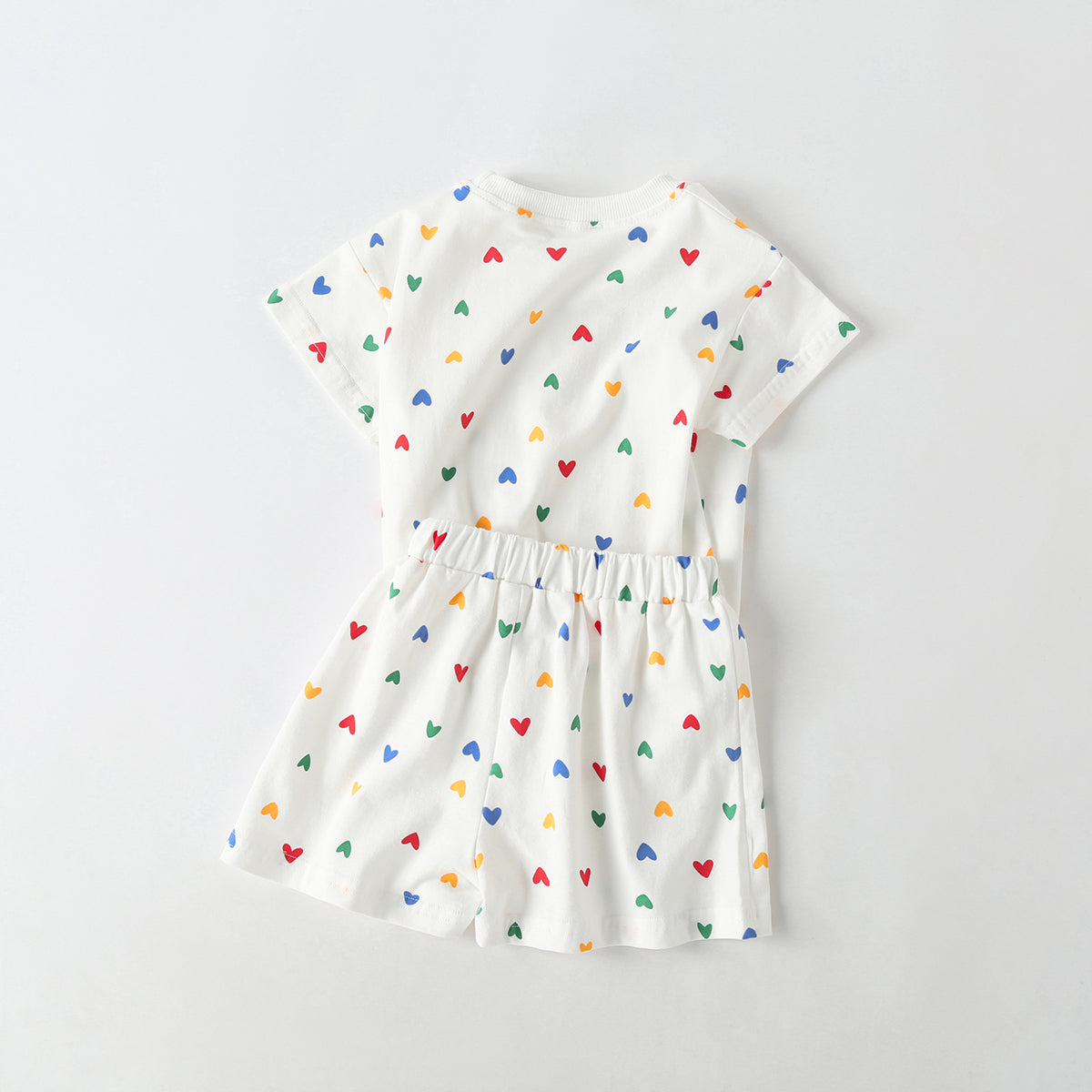 Baby outfit featuring plaid and heart patterns in a tee and shorts set, available in white and yellow colors.