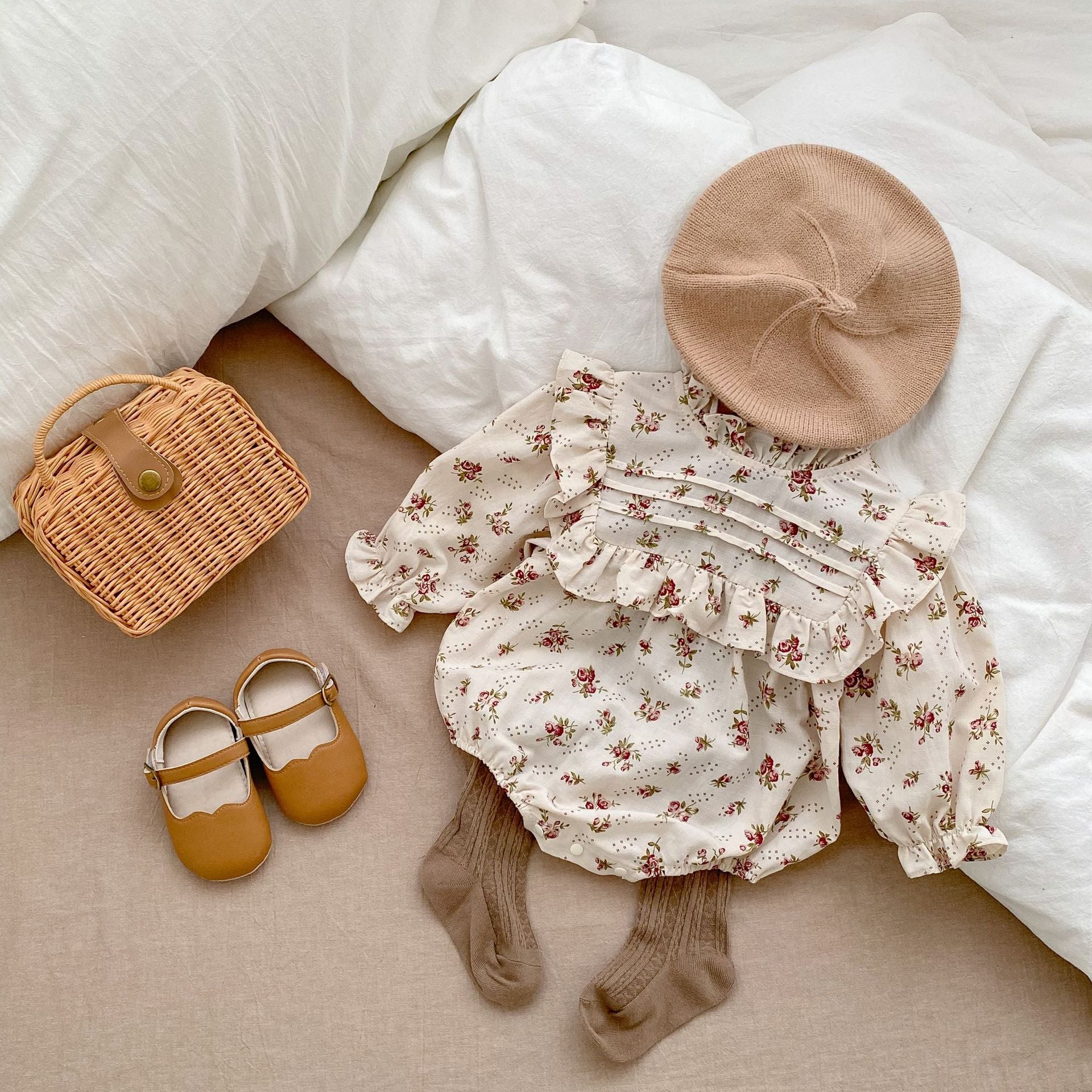 Baby girl long sleeve onesie with ruffle design in beige and apricot floral and plaid patterns.