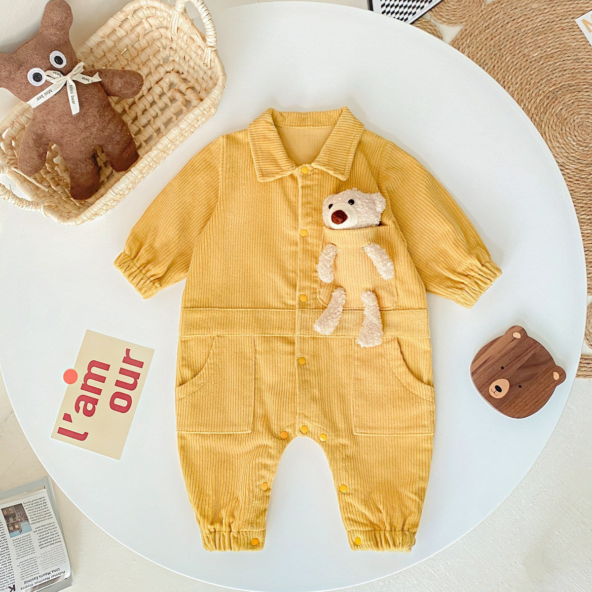 Baby romper featuring a 3D cartoon bear patch design, made from soft corduroy fabric with a button front closure, available in yellow and apricot.