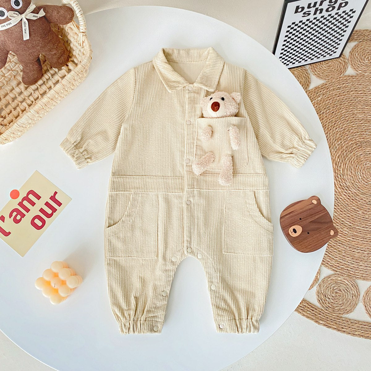 Baby romper featuring a 3D cartoon bear patch design, made from soft corduroy fabric with a button front closure, available in yellow and apricot.