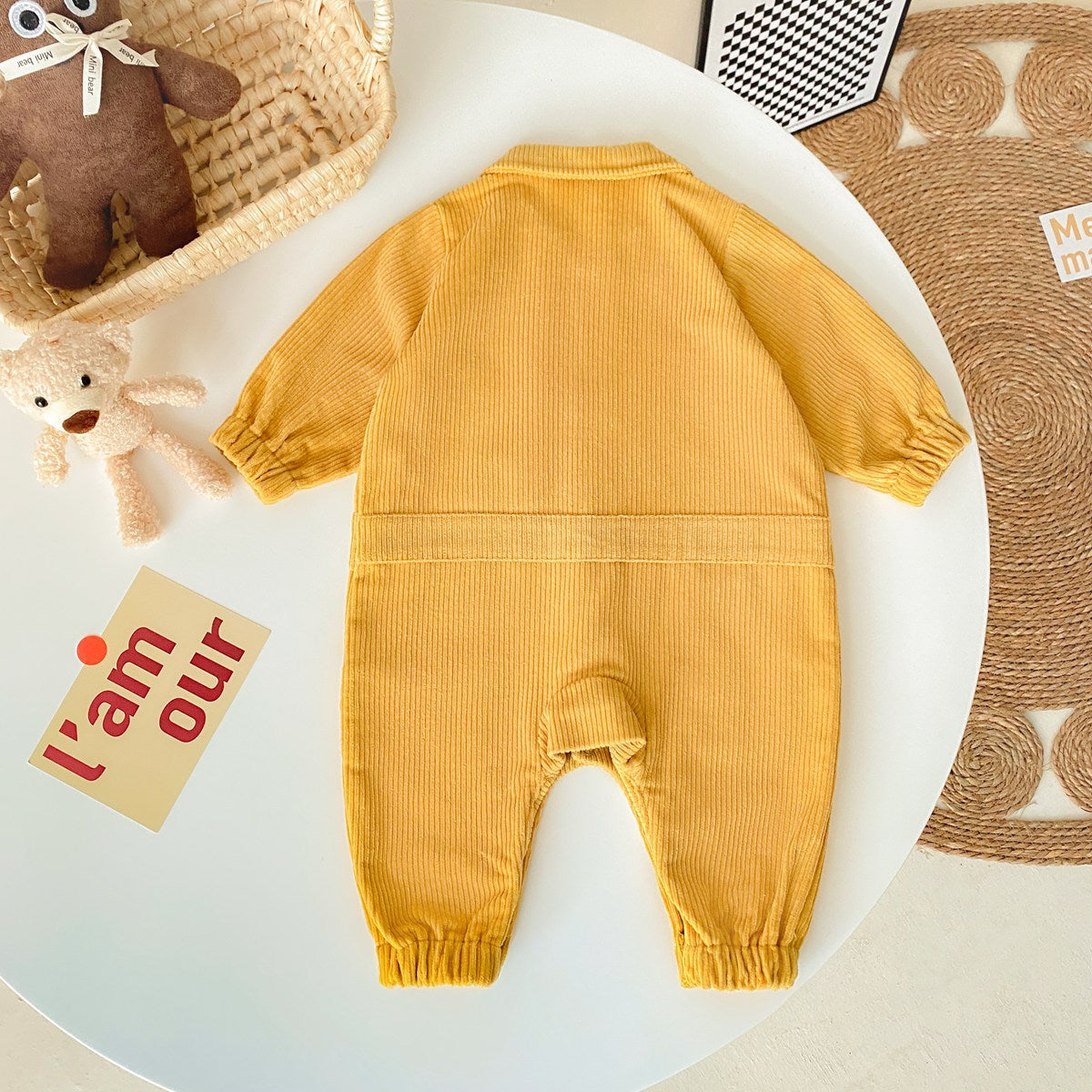 Baby romper featuring a 3D cartoon bear patch design, made from soft corduroy fabric with a button front closure, available in yellow and apricot.