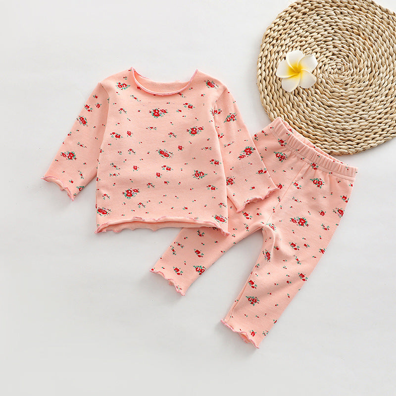 A cute baby outfit set featuring all-over print patterns in pink, yellow, and apricot colors, made from soft cotton material.