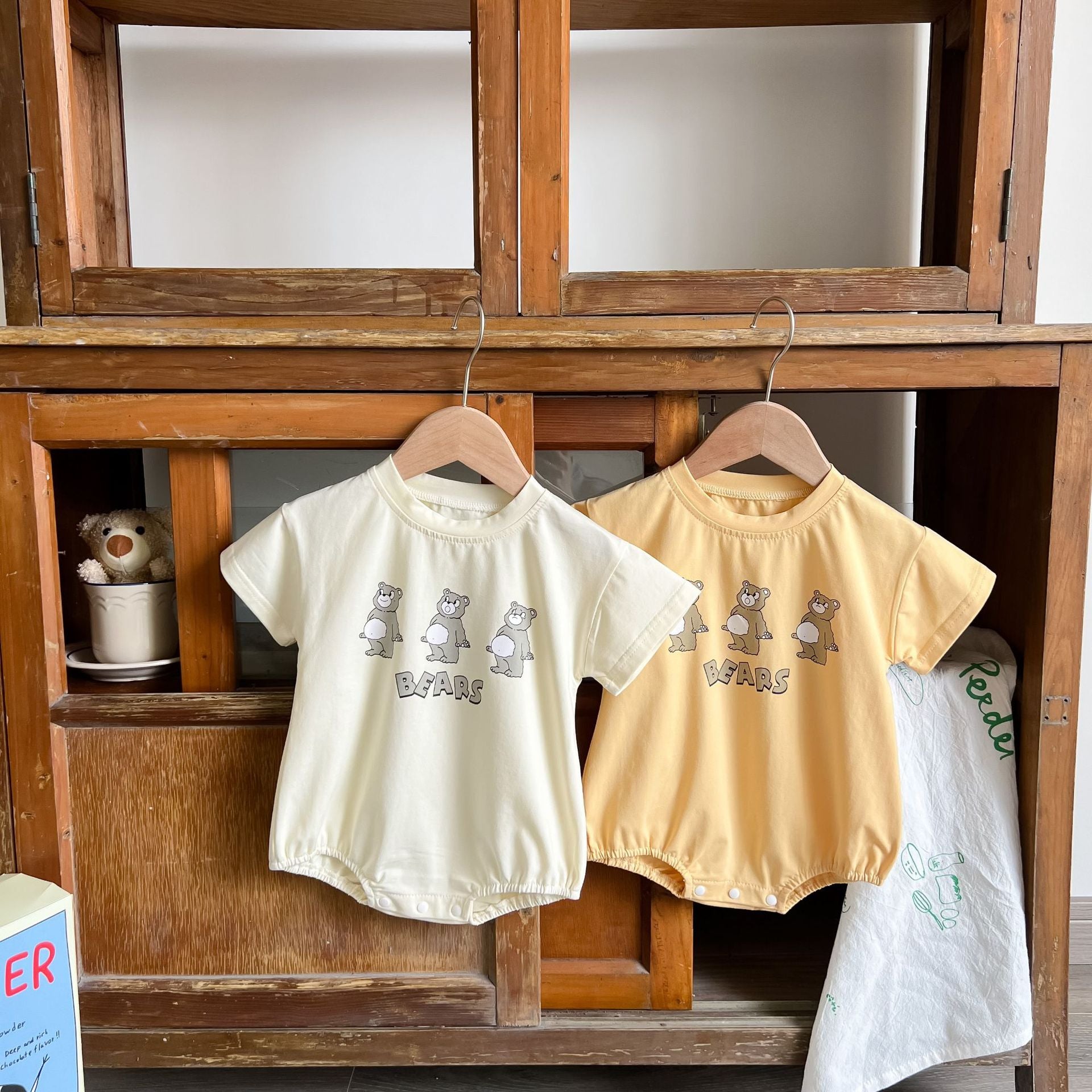 Baby boy and girl bear print onesies in white and yellow colors, featuring a cozy O-neck design made from soft cotton material.