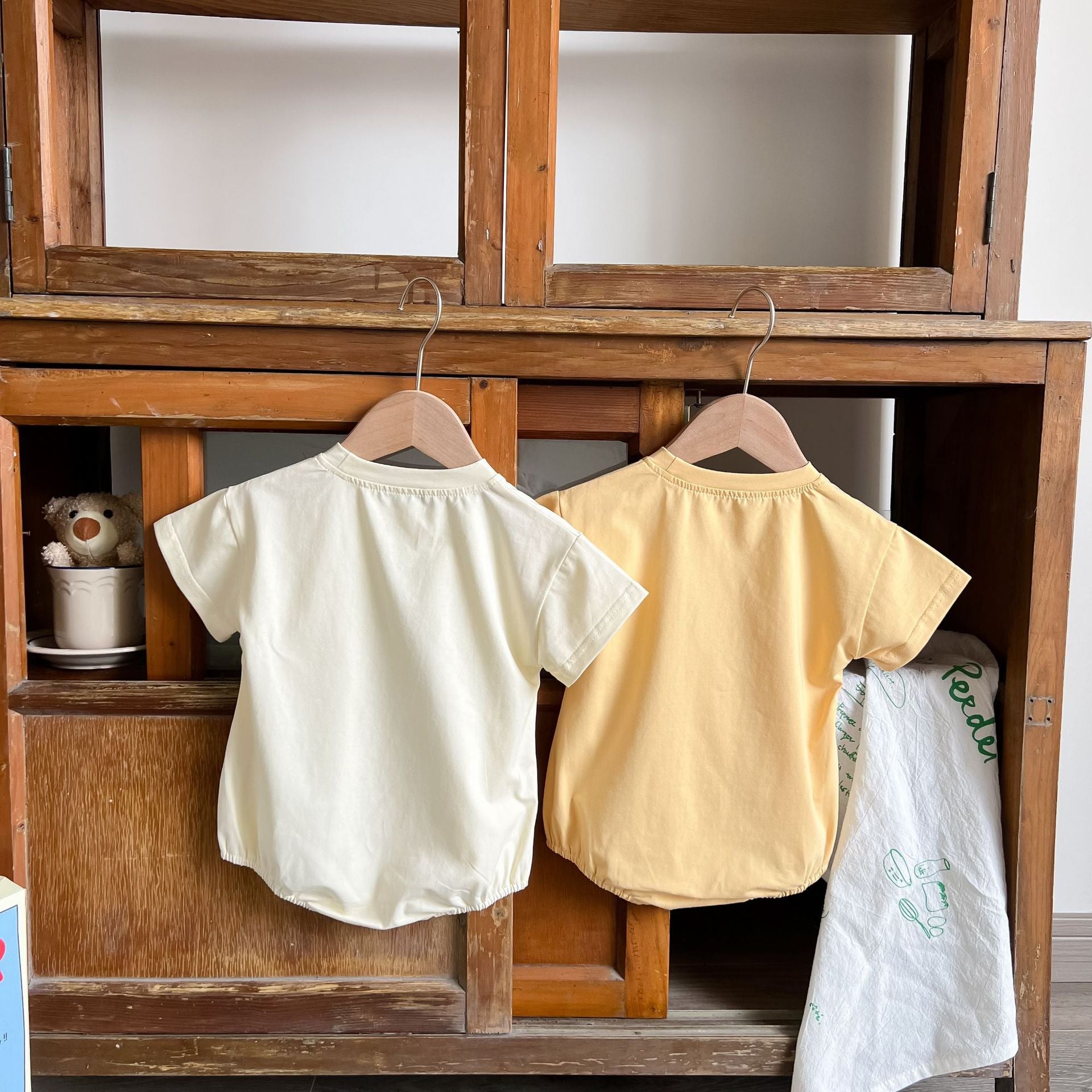 Baby boy and girl bear print onesies in white and yellow colors, featuring a cozy O-neck design made from soft cotton material.