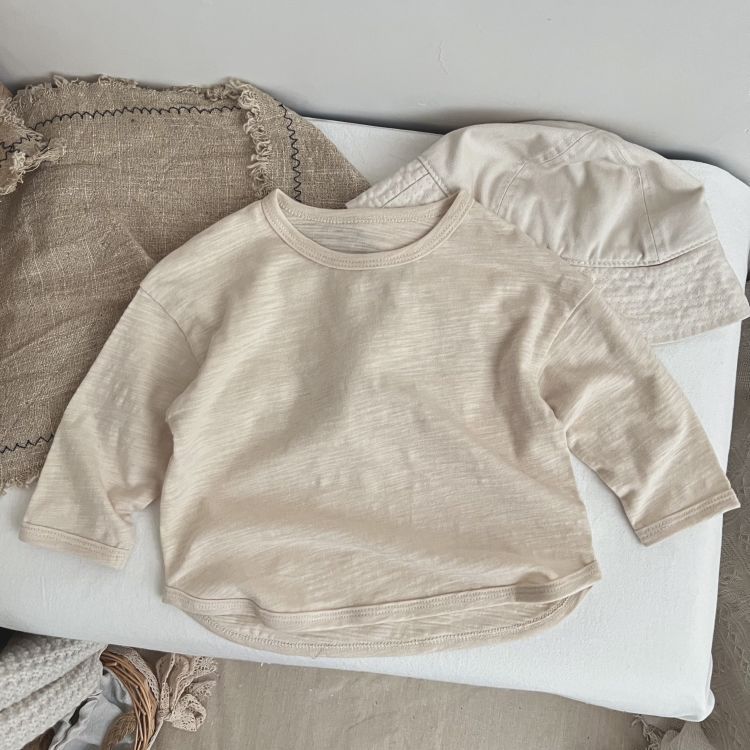 Baby boy and girl long-sleeved tops in solid colors, featuring O-neck design, made from soft cotton material.