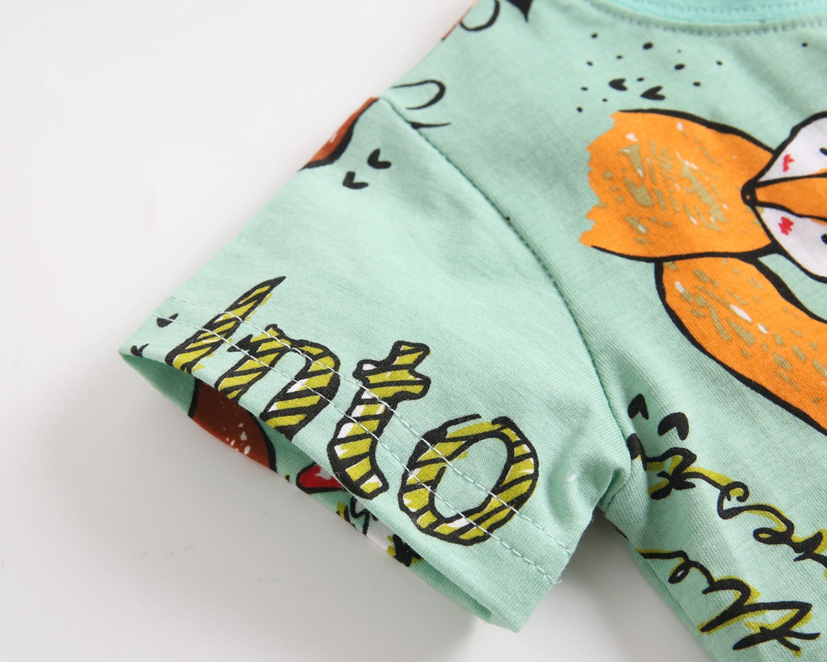 Baby boy wearing a vibrant green animal print top and solid color shorts, perfect for summer outings.