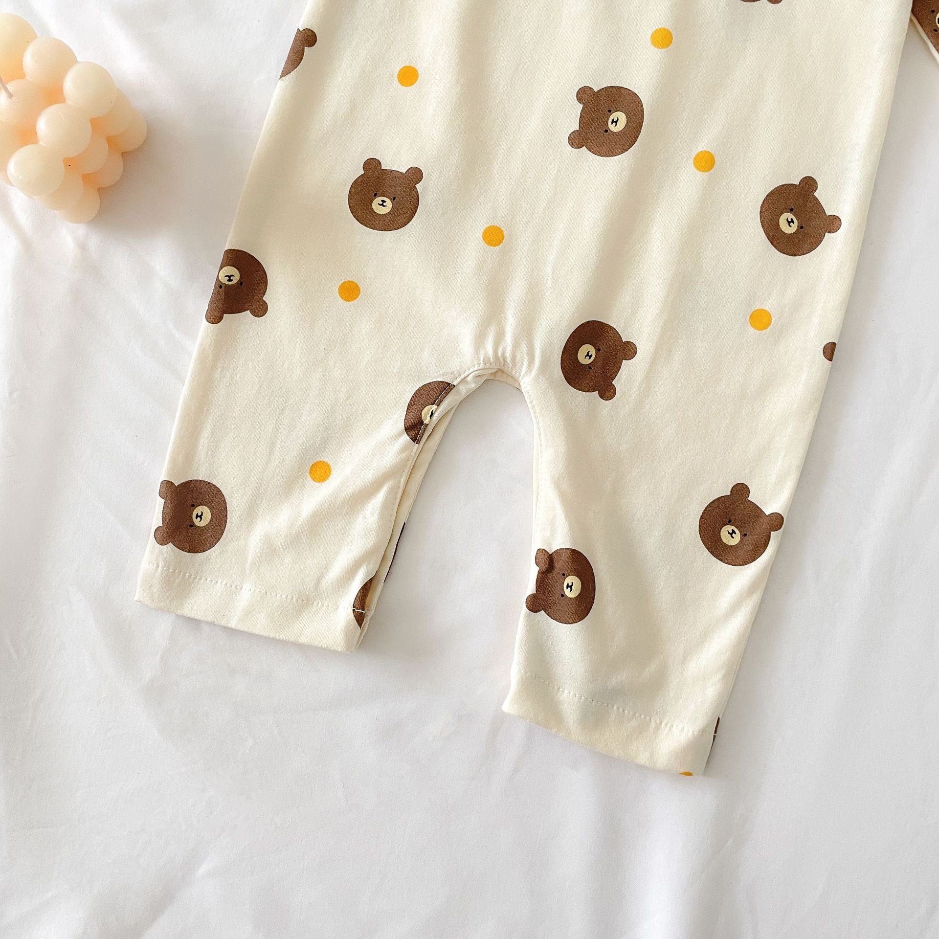 Baby boy wearing a bear pattern long sleeve polo collar romper in apricot color, showcasing a stylish and comfortable design.