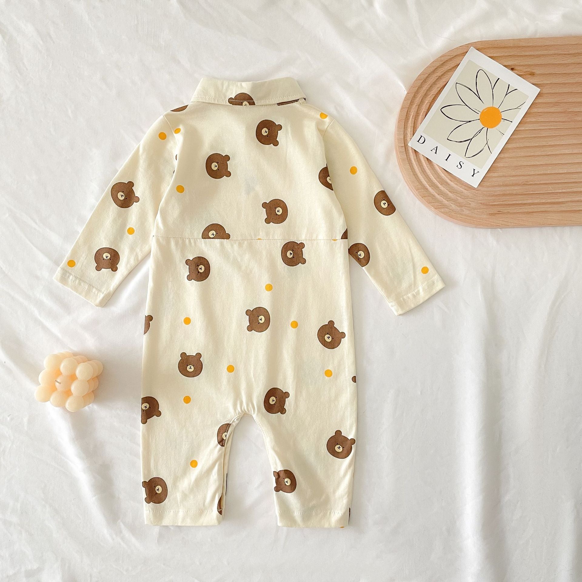 Baby boy wearing a bear pattern long sleeve polo collar romper in apricot color, showcasing a stylish and comfortable design.