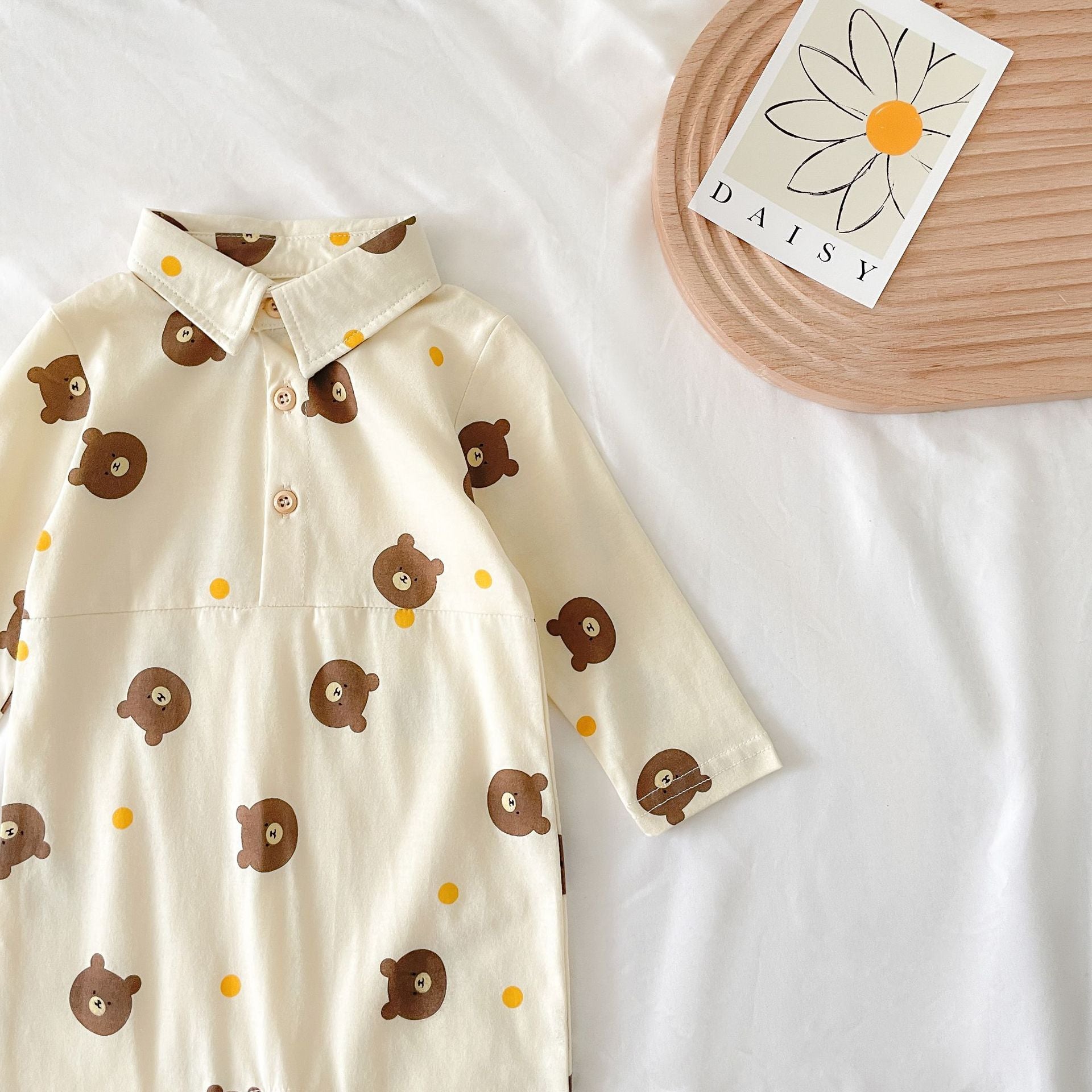 Baby boy wearing a bear pattern long sleeve polo collar romper in apricot color, showcasing a stylish and comfortable design.