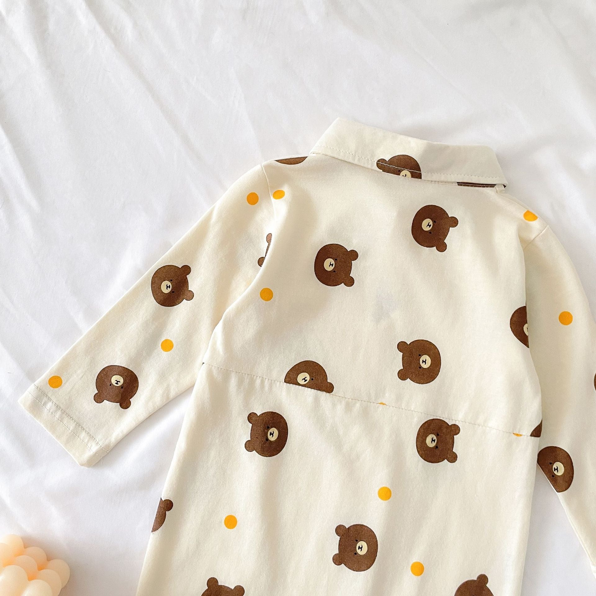 Baby boy wearing a bear pattern long sleeve polo collar romper in apricot color, showcasing a stylish and comfortable design.