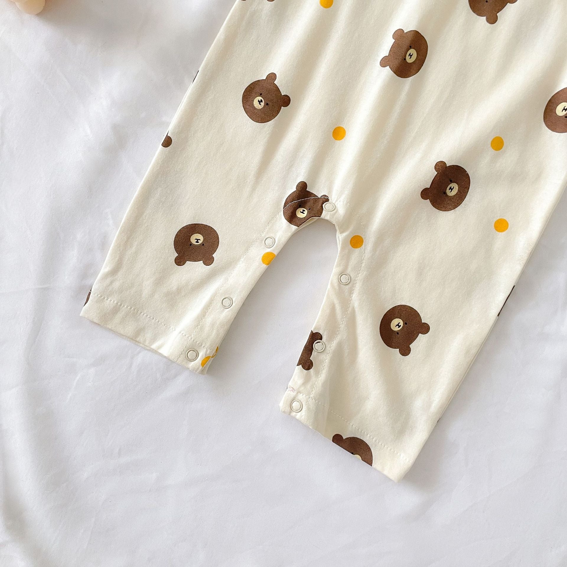 Baby boy wearing a bear pattern long sleeve polo collar romper in apricot color, showcasing a stylish and comfortable design.