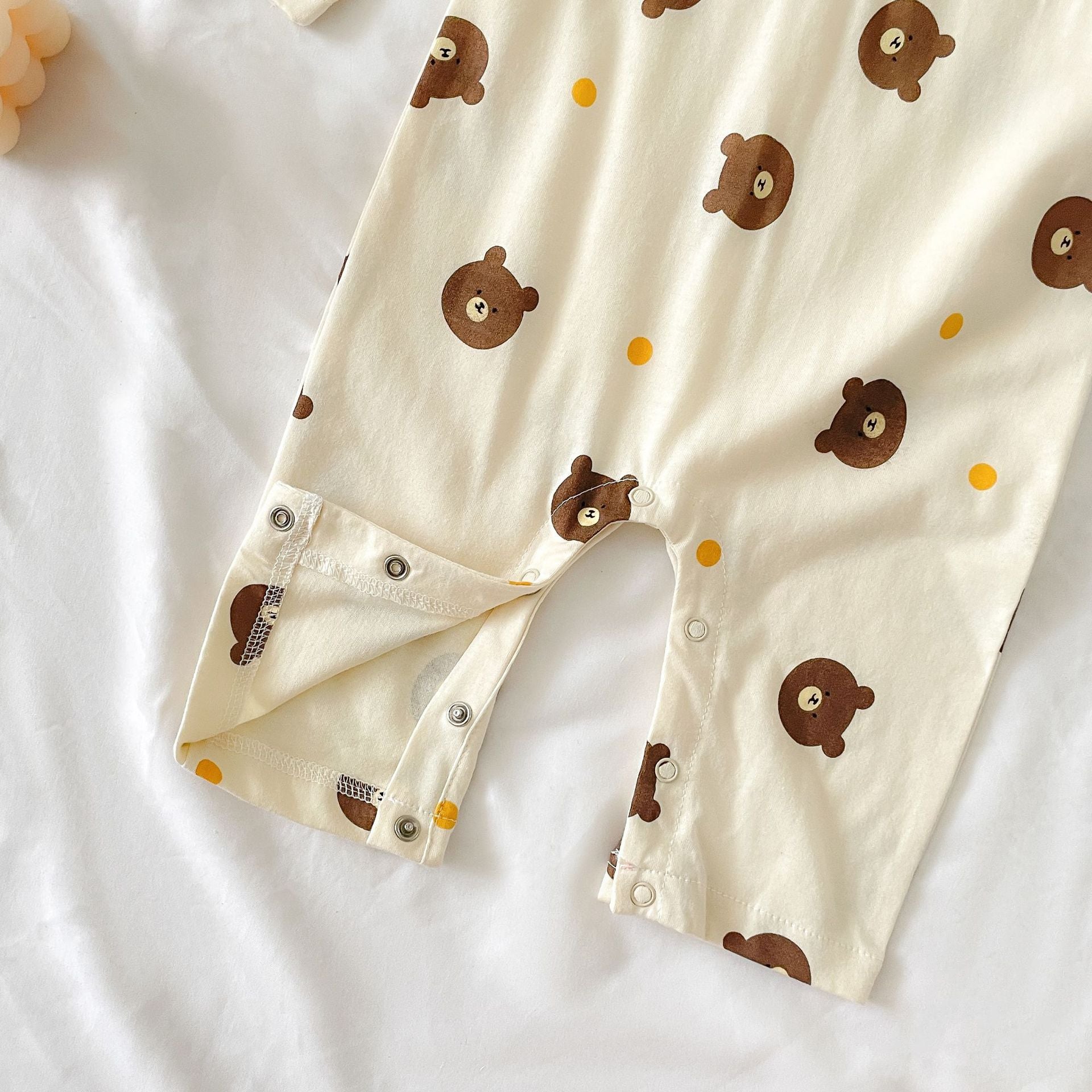 Baby boy wearing a bear pattern long sleeve polo collar romper in apricot color, showcasing a stylish and comfortable design.