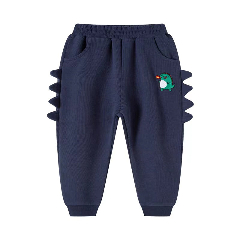 Baby boy wearing cartoon dinosaur embroidered trousers with 3D horn patches in navy blue color, showcasing playful design and comfort.