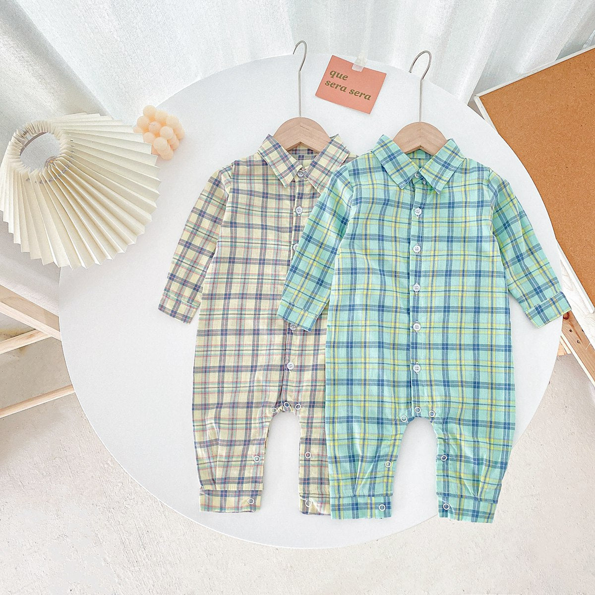 Baby boy wearing a classic plaid pattern long sleeve romper with lapel design in green and apricot colors.