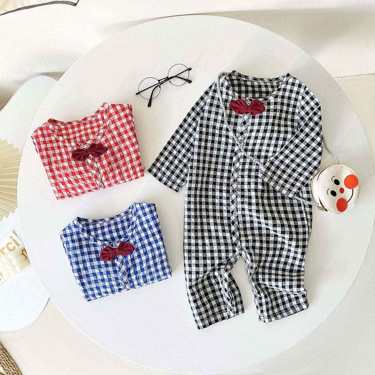 Baby boy wearing a plaid pattern cotton jumpsuit with a bow patch, showcasing comfort and style.