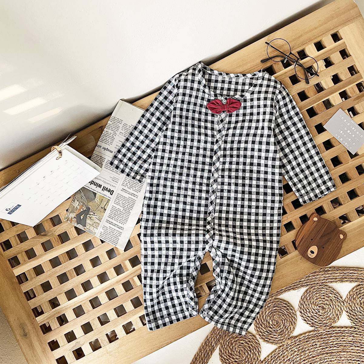 Baby boy wearing a plaid pattern cotton jumpsuit with a bow patch, showcasing comfort and style.