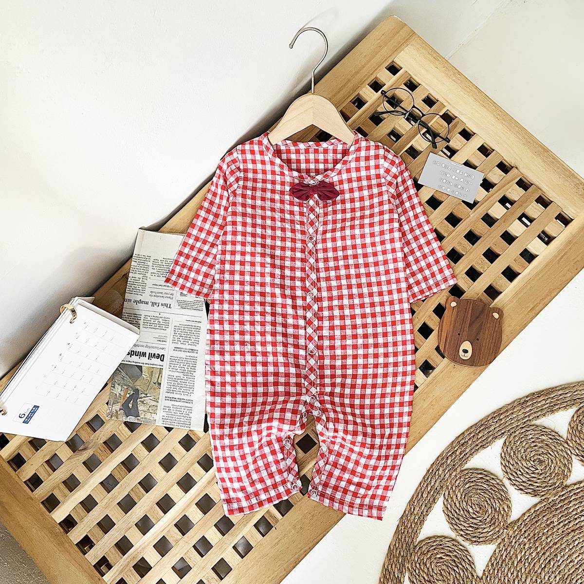 Baby boy wearing a plaid pattern cotton jumpsuit with a bow patch, showcasing comfort and style.