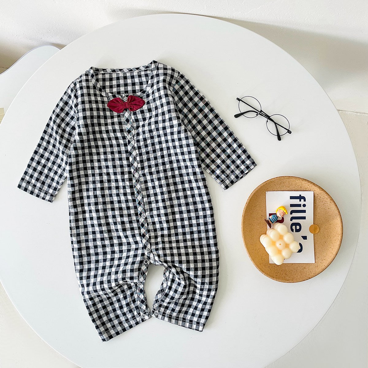 Baby boy wearing a plaid pattern cotton jumpsuit with a bow patch, showcasing comfort and style.